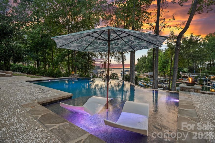 Big lot, big views, move-in ready! Incredible value at $2.495M in Cornelius with sweeping long-range main channel views of Lake Norman, this exceptional waterfront retreat rests on nearly an acre and offers an updated, move-in ready residence designed for effortless living and entertaining. The cozy yet open layout is filled with natural light, featuring walls of windows and glass doors that open to a lakeside screened terrace, a spacious chef’s kitchen with eat-in breakfast area, and an oversized primary suite with spa bath and large walk-in closet on the main level. Upstairs offers three generously sized bedrooms, a large bonus area, and dual staircases for flexible living. The expansive backyard oasis showcases a new saltwater pool (2024), lakeside firepit, and private dock with 7,000 lb boat lift, making this a rare opportunity to own a large waterfront lot with big views and exceptional outdoor living in one of Cornelius’ most sought-after lakefront locations.