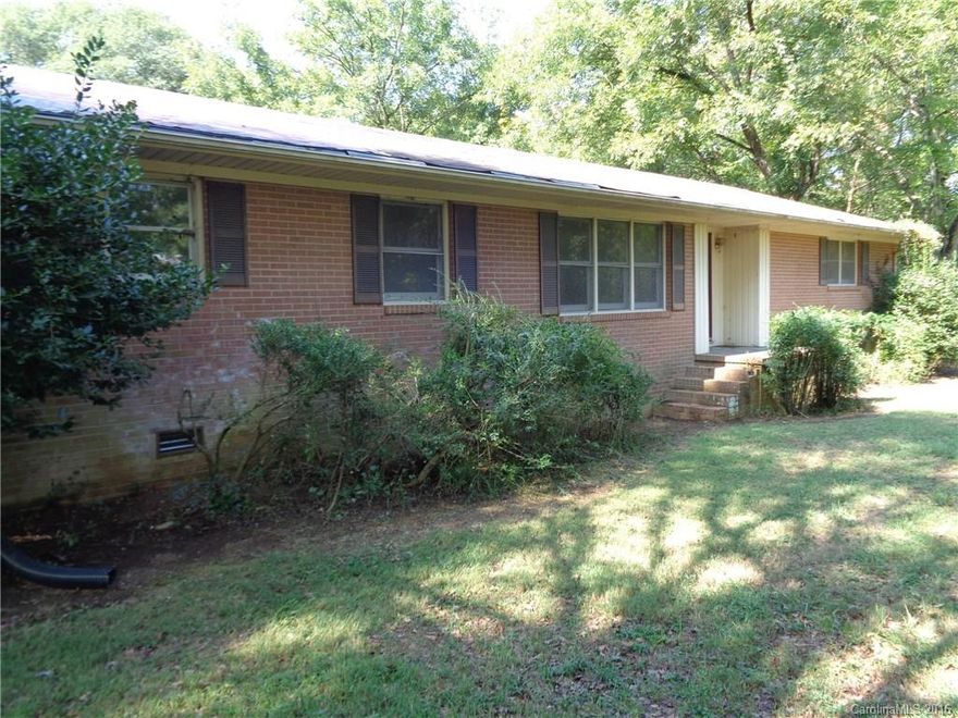 Brick house on three acres with back porch.Has four bedrooms,two full baths, living room, open kitchen dining area. NO septic permit on record. Buyer should inspect discoloration  under the house on wood.