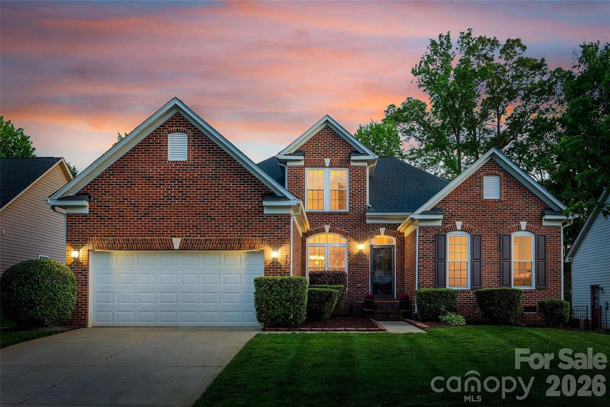 Nestled in a treed backdrop, the pristine landscape of this home is nothing short of perfection! With full irrigation, a fenced yard, and carefully manicured flower beds, you can enjoy the view from the composite deck and 3-season room that make this home stand apart from others. As you enter the brick-front home, the open and bright floor plan features a primary suite on main, and welcomes you into a formal dining room. It flows into the expansive great room, which is anchored by a gas fireplace. The kitchen boasts stainless steel appliances, Corian countertops, and opens to a breakfast area, and sunroom with loads of natural light! The deck has a motorized retractable awning (that even auto-closes when windy), is lighted for a gorgeous nighttime ambiance, and provides an additional area to entertain or enjoy a cup of coffee. The three-season room has both screens and a vinyl pane system, so you can enjoy the outdoors almost year-round! Downstairs you'll find an expansive primary suite with a tray ceiling and walk-in closet, and a bathroom featuring dual sinks, a walk-in shower, and a garden tub. The split bedroom floor plan has another 2 bedrooms and a full bath on the main level. Upstairs you'll find the 4th bedroom and another full bath, providing extra space and flexibility! Lots of extra details to be found including heavy molding throughout the home, cabinets in the laundry room, a utility door from the garage to the outside, and more. Roof was replaced in 2023, all new windows in 2023, new tankless hot water heater in 2019, and new HVAC in 2018. The community has an outdoor pool, playground, sidewalks and street lights, and is in a central location in Fort Mill - with low SC taxes and award-winning schools, look no further for your next home!