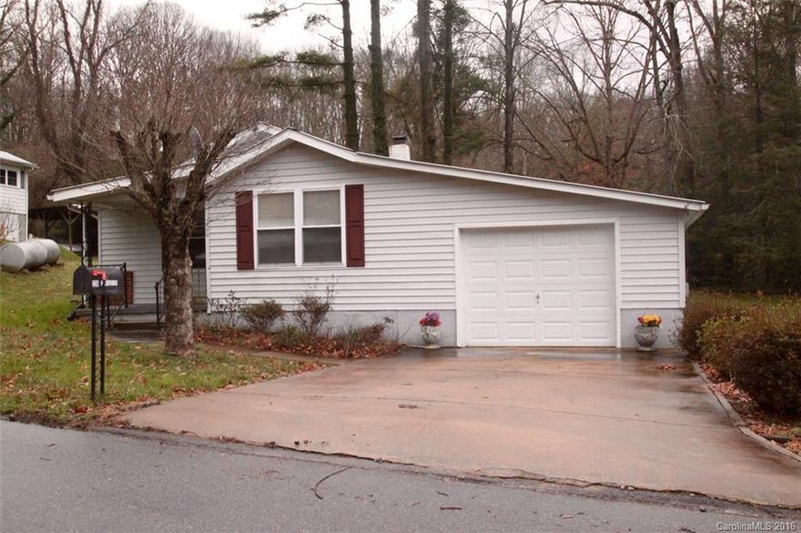 Adorable bungalow oozing with charm on a quiet tree lined street walking distance to shopping, downtown Waynesville. The level yard is perfectly situated for children's play or a garden area complete with detached storage.  The cottage home features insulated, replacement windows, gleaming wood floors, updated kitchen and baths and a convenient laundry/mud porch. The attached single garage adds convenience and storage.  Low maintenance exterior boasts vinyl siding and metal roof for easy living.