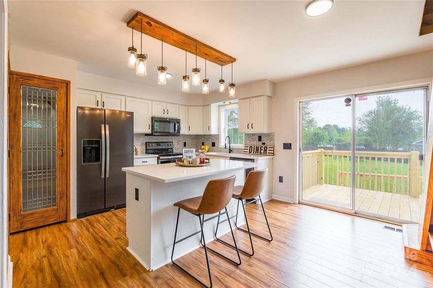 This truly adorable property is a dream come true! The stunning kitchen features white cabinets, a farmhouse sink, and elegant quartz countertops complemented by brand-new black fixtures. Bright new lighting fills the space, and fresh carpet throughout all three bedrooms adds a cozy touch. The bathrooms have been upgraded with new toilets, and the entire home has been freshly painted. Custom wooden stairs lead to a versatile attic space that is partially floored for storage, ideal for a future bedroom or bonus room. Enjoy the outdoors with a new front railing, a new side deck, and an impressive double-level back deck perfect for entertaining. Recent enhancements include new insulation, a new vapor barrier and a new roof along with a 2024 HVAC system and a new hot water heater!  Located in a serene country setting close to Gastonia and just minutes from the airport, this home has no HOA—truly the perfect blend of convenience and charm!