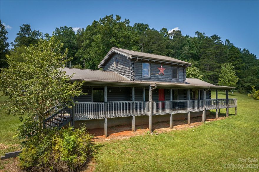 Beautiful log cabin sitting on just over an acre!  The full-length front porch overlooks sweeping fields and close-range mountain views!  The open concept living area includes the kitchen with custom cabinets and vaulted ceilings.  On the main level are two primary bedrooms with ensuite baths!  One primary bedroom has a garden tub and french doors leading out to the covered front porch.  The upstairs loft is open to the main living area below but is perfect for an office or flex space!  This beautiful log cabin won't last long!