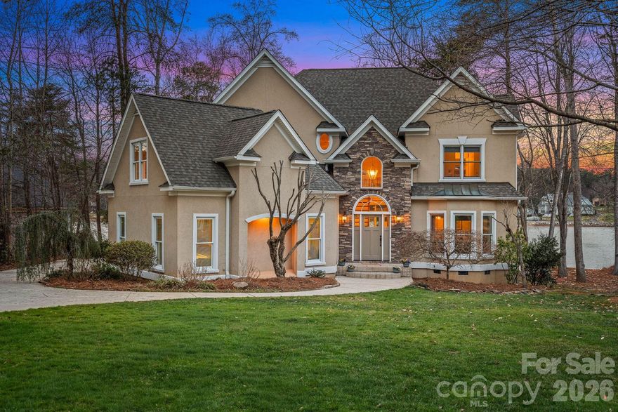 Welcome to the ultimate Lake Norman lifestyle. Nestled on a lush 0.70-acre lot with 110 feet of private shoreline, this home delivers year-round Sunset water views and a private dock in an unrivaled setting. Step inside to find a residence refreshed and ready for its next chapter, featuring fresh interior paint (February 2026) throughout the main living areas and elegant finishes at every turn. The experience begins in the two-story foyer, where a statement light fixture and a grand staircase with iron balusters set a sophisticated tone. Host formal dinners in the dining room featuring a stunning beaded chandelier and bay window, or utilize the fully equipped butler’s pantry—complete with granite countertops, a bar sink, and a built-in microwave and dishwasher—for seamless hosting.

The gourmet kitchen is a chef’s dream, featuring an oversized granite island with bar seating, professional-grade stainless appliances including a 5-burner gas cooktop, and custom cabinetry with an appliance garage and stylish glass-front accents. Adjacent to the kitchen, the breakfast area offers spacious views and direct access to the oversized back deck. The two-story great room is anchored by a gas fireplace and built-in cabinetry, featuring a spectacular wall of windows and sliding glass doors. For guests, the main level includes a dedicated suite with hardwood flooring, a tray ceiling, and a full en-suite bath.

The upper level is designed for comfort and privacy, connected by a loft catwalk overlooking the great room. The owner's suite serves as a true sanctuary, entered through double doors and featuring a bay window sitting area overlooking the lake, along with a massive two-room walk-in closet with custom shelving. The grand spa-like bathroom offers an oversized vanity, a Jacuzzi tub with natural light, and a tile-surround walk-in shower with dual heads and a frameless glass door. Two additional bedrooms each provide private vanities and walk-in closets with access to a shared bathroom, while a massive bonus room with dual attic access offers the perfect footprint for a home theater or gym.

Outdoor living is effortless and expansive. The multi-level deck features a retractable awning and multiple seating areas, making it the premier spot for sunset cocktails. Follow the concrete walkway through professional landscaping down to your 110 feet of shoreline and private dock, complete with an iron-railed pier and floating boat slip. Modern conveniences abound, including a central vacuum system, a dedicated laundry room with built-in cabinetry, and an oversized garage with a large storage area. This property offers the perfect balance of privacy and prime lakefront access. 

Community amenities include a pool, two tennis courts, two new pickleball courts, volleyball, basketball, a clubhouse, and a playground.