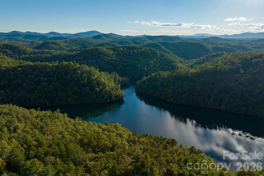 Discover an extraordinary legacy property offering 1,429 acres of pristine natural beauty, including the breathtaking backdrop of Shoal Creek Falls. This remarkable estate boasts 1.8 miles of picturesque shoreline along the enchanting Lake Apalachia, sharing its frontage with the Nantahala National Forest and conveniently located minutes to the charming town of Murphy and two hours or less to Asheville, Atlanta, Chattanooga, and Knoxville.

Twelve miles of well-maintained gravel roads and underground electrical utilities lead to building sites overlooking serene Lake Apalachia, with its world-class trout fishing, tranquil atmosphere, and minimal recreational boat use due to its remote access points. This property offers abundant opportunities for development–explore the scenic roads and witness the potential of these prime building locations; whether it’s a nature preserve wellness retreat or a legacy tract for future generations, the options are infinite. There are no restrictions or conservation easements in place, offering potential tax benefits for conservation-minded buyers. Enjoy close proximity to the airport with a 5,500 foot runway that will accommodate private jets.••Highlights•• 1,429 acres•Expansive and private retreat•Shoal Creek Falls adds a stunning scenic backdrop•1.8 miles of Lake Apalachia shoreline (and world-class trout fishing)•Secluded location within the Nantahala National Forest•Minutes to the charming town of Murphy, NC•Two-hour drive or less to Asheville, Atlanta, Chattanooga, and Knoxville•Well-maintained infrastructure accessible via 12 miles of well-maintained gravel roads•Underground electrical utilities in place•Prime building sites (multiple sites overlooking Lake Apalachia)•Recreational opportunities, such as hiking, biking, hunting, and fishing•Development potential as possible wellness retreat, legacy tract for future generations, or thoughtfully planned community•No restrictions or conservation easements in place•Tax benefits for conservation-minded buyers•Includes 3,000 square foot modern residence, charming barn, and smaller outbuildings•Close proximity to Western Carolina Regional Airport in Andrews, NC, with a 5,500-foot runway to accommodate private jets