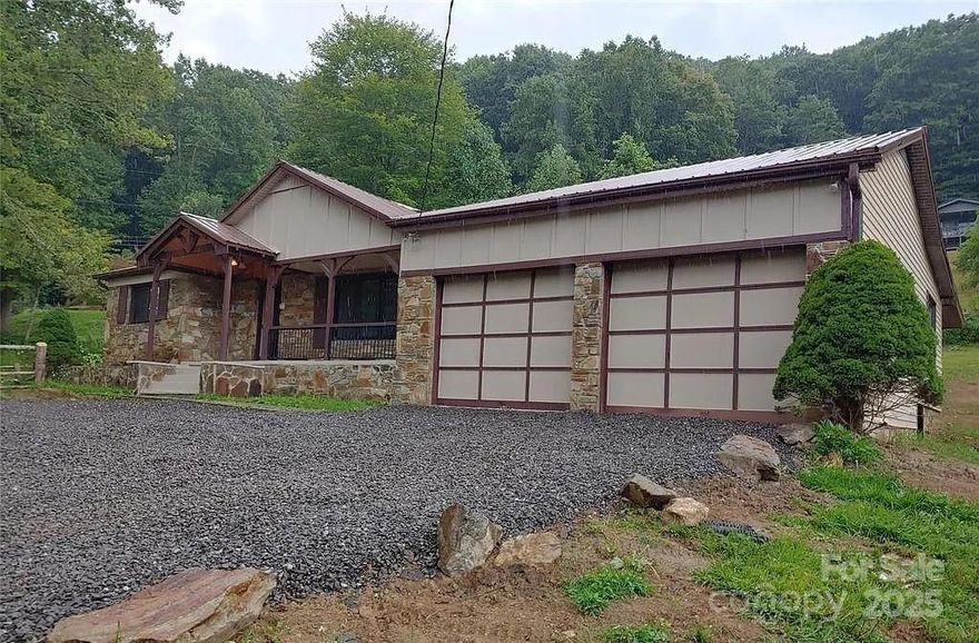 Great location in the Newdale Community, conveniently situated between Burnsville and Spruce Pine. Just off 19E, making commuting in either direction easy. Both towns regularly host art shows, car shows, and more. This home has been completely remodeled, featuring vaulted ceilings, central AC, new flooring, and a designer kitchen. The master suite includes a walk-in closet and a large master bath. The open floor plan creates a spacious feel. Additionally, there are two outbuildings and a large 2-car garage. The new driveway with a turnaround is just completed, and the yard has been seeded, starting to look beautiful. The property sits on a 1-acre lot with a ranch-style fence and plenty of trees. It's very easy to maintain and is located in a great neighborhood. It appears from the satellite view that the property is right next to the farm supply store next in all actuality young tractor and farm surely is on the other side of the mountain not viewable from the property. With sizeable deposit owner finance is possible. Call for details.