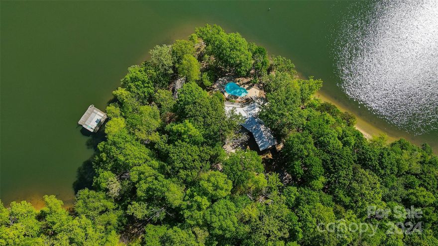 Truly a rare find and a “one of a kind” property within the Gated community of Handsmill, yet not part of the HOA. 
Located on a private 1.7 acre point lot with approximately 550’ of shoreline, beautiful hardwood trees, and AMAZING panoramic views of Lake Wylie.  Designed to enjoy the outdoors and lake living this 1 level waterfront retreat features 3 bedrooms, 3 baths, vaulted ceiling, unfinished basement, and plenty of windows to enjoy the lake views. Can be enjoyed “as is” for weekend retreat or update when ready. You’ll love the wrap around deck, in ground swimming pool, and floating boat house that are perfect spots for outdoor entertaining or just to relax & take in the glorious main channel views.  Home is currently on well and septic but York County sewer is located at the road.  Owner receives free access to most Handsmill amenities at no cost.  Clover schools, SC taxes, convenient to restaurants, and shopping.