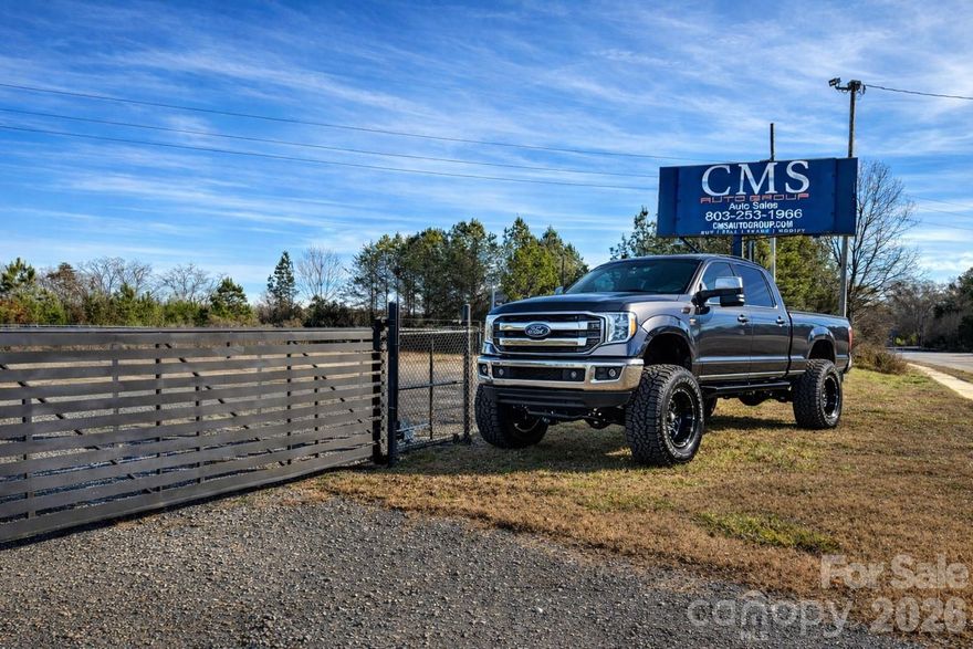 Highly visible commercial property with direct frontage on high-traffic road just south of booming town of Clover.  Ideal for a used car dealership or automotive sales operation. The site includes a move-in-ready office and a fully fenced gravel lot with automated gate, providing secure inventory and customer parking.

Commercially Zoned for outdoor storage and sales, allowing for vehicle display and dealership operations by right. A large roadside banner is included for immediate advertising exposure. The lot offers ample space for vehicle inventory, equipment, or fleet parking.

Suitable for auto dealerships (cars, trucks, RVs, boats, motorcycles), towing or repair services, equipment sales, and other outdoor-oriented commercial uses. Excellent visibility, flexible zoning, and functional layout make this a strong opportunity for owner-users or investors.