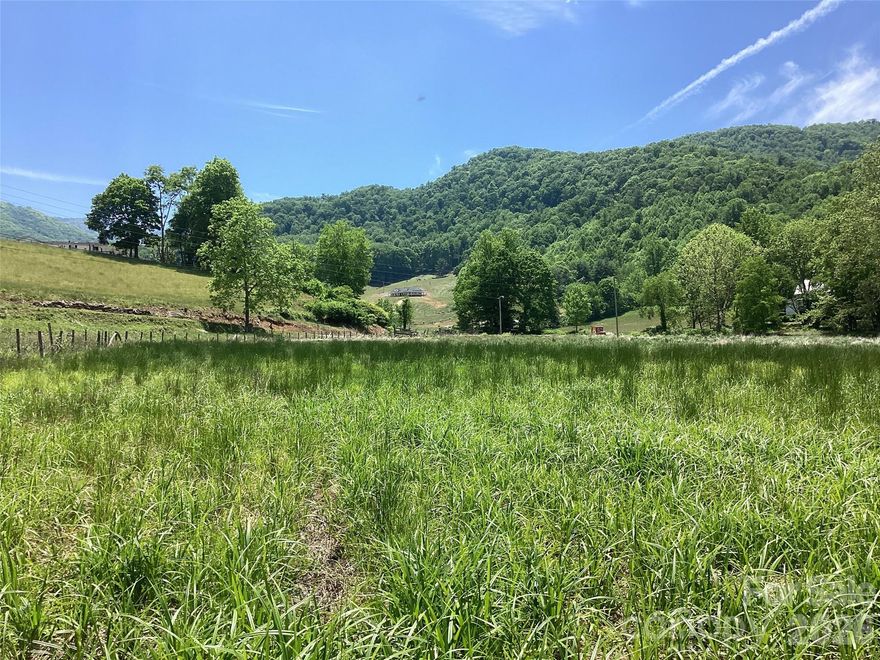 Just outside the quiet mountain town of Burnsville, NC, this 7± acre tract rests where the land begins to slow down and open up. With more than 1,000 feet of frontage along Bolens Creek Road and additional access from a private road, the property is easy to reach while still feeling tucked away in the Blue Ridge Mountains of Western North Carolina. The land itself is unusually gentle for the mountains. It is mostly flat with usable, tillable ground that has long inviting gardens, small farms, or simply room to spread out. Along the back boundary, Bolens Creek winds the property line, adding the steady sound of moving water beneath the backdrop of the Blue Ridge Mountains rising in the distance. Already perc’d for a 3-bedroom septic system, the tract is well suited for a mountain homestead, family retreat, or investment for the future.  Unrestricted land, no zoning and just three minutes outside the Burnsville city limits, your mountain land vision has room to become reality.  If you’re looking for a slower pace and natural beauty in Western NC this is an ideal location.  This is the kind of property where mornings begin with mountain views, evenings end by the creek, and the land itself gives you the space to build something lasting.