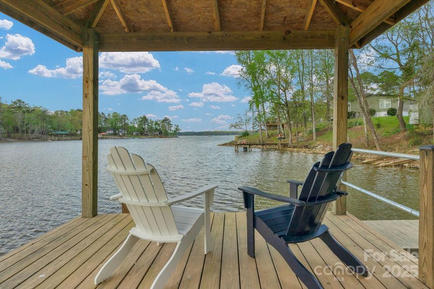 Searching for a fabulous waterfront Lake house?  Your search is over!  This home is perfectly nestled on a .78 acre lot, w/ panoramic Lake views year round!  165 feet of Waterfront, NEW dock, w/covered deck and NEW boat lift.  Like to entertain?  You have over 1,160sf of exterior space to choose from and take in the expansive Lake views. You're gonna love the Stone perimeter seating walls!  This beautiful Chalet style home offers an OPEN floor plan, HIGH ceilings, WALL of windows and french doors that lead to the deck.  Main level has hardwood flooring, Bedrooms/living/dining areas, 2nd level has LOFT w/ amazing views, spacious Primary Suite. The partially finished basement is 1,104 sf heated/cooled, FULL Bath w/Laundry - addl Entertaining, play/sleeping - (2) sets of French doors to let the Sunshine in and the View is equal to the Views from the main level.  Home currently has sleeping accommodatoins for 12+ people.  Convenient to Columbia & Charlotte (is only little over 1 hour away)