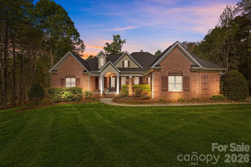 Opportunities like this are becoming increasingly rare — custom-built full brick home set on 2.76 private, wooded acres in a gated community — offering a level of privacy, craftsmanship, and character that is increasingly hard to find in today’s market.
A long private driveway and manicured landscaping create a true sense of arrival, leading into an open, thoughtfully designed layout highlighted by vaulted and coffered ceilings, extensive millwork, solid wood doors, and rich hardwood flooring throughout the main living areas.
The vaulted family room is anchored by a floor-to-ceiling stone fireplace and flows seamlessly into the kitchen and keeping area—creating a natural gathering space ideal for both everyday living and entertaining.
The kitchen features granite countertops, a large center island, stainless steel appliances, and a striking exposed brick accent wall with custom wood mantle—a standout design element rarely found in typical new construction.
The primary suite on the main level offers a true retreat, complete with a coffered ceiling and a private sitting room or home office behind French doors. The en-suite bath includes dual vanities, a soaking tub set within an arched alcove, a walk-in tiled shower, and an expansive walk-in closet w/ custom shelving.
Outdoor living is almost more impressive, with a covered back porch featuring a beadboard ceiling and Trex decking, overlooking a peaceful, wooded backyard that provides exceptional privacy and usable space.
Additional highlights include a formal dining room with detailed trim work, multiple flexible living areas, spacious secondary bedrooms, private upstairs bedroom w/ full bathroom and an enormous walk-in attic, and a 3-car side-load garage.
Homes offering this combination of acreage, privacy, and custom craftsmanship—within a gated community—are increasingly rare, especially in such a convenient location near Lake Norman. Schedule your showing early to experience it in person.