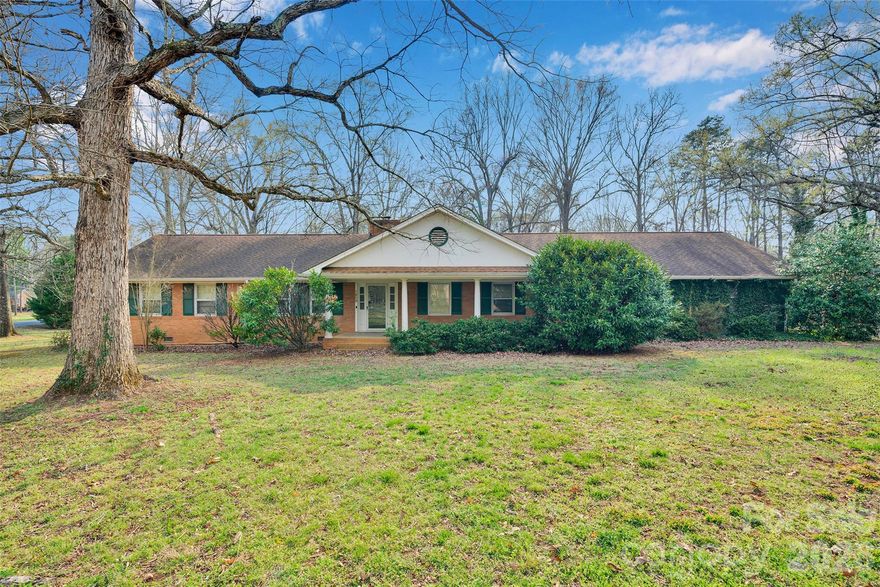 Looking for space, potential, and location? This spacious 4-bedroom brick ranch in Monroe, North Carolina sits on a 1.07-acre corner lot and offers over 2700 square feet of living space.

This traditional single-story home has solid bones and a great floor plan, making it a fantastic opportunity for investors, renovators, or buyers looking to create their dream home. The home features multiple living areas including a living room, great room with fireplace, dining room, office, sunroom, and large kitchen area, offering plenty of flexibility for modern updates.

Outside, enjoy the privacy and space of an acre-plus lot with mature surroundings and a two-car carport, plus additional room for outdoor living, gardening, or expansion. The corner lot location in Carmel Village provides added curb appeal and convenience while still offering a peaceful setting.

Located just minutes from downtown Monroe, shopping, dining, and major roadways, this property combines country-style space with city accessibility.

With the right updates, this home could truly shine. Bring your vision and unlock the potential of this Monroe fixer-upper.
