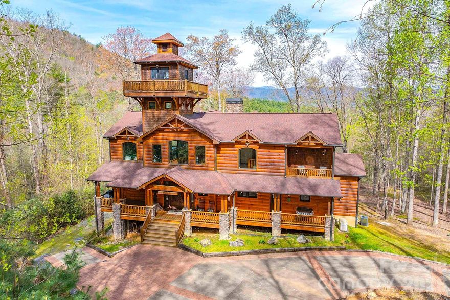 Set within the private gates of Round Mountain Falls, this exceptional mountain retreat captures the essence of refined, yet relaxed, Blue Ridge living. Offering 13.41 acres across three lots, the property provides remarkable privacy paired with breathtaking long-range mountain views that unfold from nearly every vantage point.

Designed with character and intention, the home features a striking cupola—an architectural centerpiece that serves as an intimate library, complete with a surrounding viewing platform for taking in the expansive scenery. Inside, rich textures and timeless materials define the living spaces, highlighted by impressive rock fireplaces in both the main living room and primary suite, creating a warm and inviting atmosphere throughout.

Thoughtfully planned for both everyday living and entertaining, the home includes a well-appointed bar, multiple decks, and covered porches that seamlessly extend living outdoors. Interior spaces offer flexibility and comfort, with a dedicated office, exercise room, and a workshop for hobbies or storage. The kitchen is anchored by a Viking gas range, with additional high-end appliances to follow, blending performance with mountain-modern style.

Modern conveniences such as a whole-home generator provide peace of mind. The additional acreage presents a unique opportunity, with the potential to market remaining lots separately.

Located within a gated community featuring a pavilion, scenic creeks, and a network of hiking trails, this property delivers a rare combination of privacy, acreage, and lifestyle—just moments from the natural beauty that defines the region.