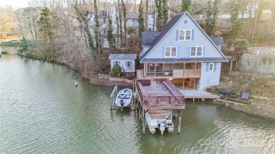 Rare opportunity to own one of the most coveted lots in a cute cove, on Lake Wylie above dam level in Rock Hill, SC. Offering stunning views & endless possibilities, this prime lakefront property is a dream for water enthusiasts! Duke permitted covered dock & floating dock (grandfathered in), a boat, a paddle boat, great outdoor space and great potential. The A-frame home is very unique and an estate sale, being sold AS-IS; no repairs or credits for repairs. Newer roof & recent installation of helical piers to support portion of house on top of the lake. Whether you’re looking to create a custom retreat or invest in a premier lot with unique perks, unmatched waterfront access & unparalleled convenience this property offers such great potential! This is priced for the waterfront lot & opportunity for you to come & have your dream waterfront home. Call LA for details and all important details