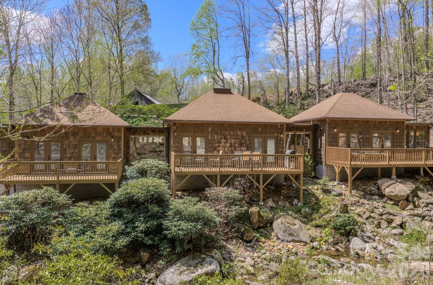 Escape to the quiet beauty of the mountains with this thoughtfully designed retreat, where peace and relaxation take center stage. Nestled in the serene landscape of Bakersville, this 2 bedroom, 2.5 bath home offers a perfect balance of comfort, privacy, and natural charm.

Inside, the inviting living space is complemented by warm wormy maple kitchen cabinetry and custom built-in benches with hidden storage blending functionality with timeless mountain character. Large windows invite the outdoors in, allowing you to take in views of the gently flowing creek while also hearing its soothing sounds from within the home creating a truly immersive, calming environment.

Outdoors is where this property truly shines! Three spacious independent private decks overlook the tranquil creek, offering the perfect setting for morning coffee, quiet reflection, or evening relaxation. A propane gas hookup makes outdoor dining effortless, while the warm-water exterior hookup provides the opportunity to create a spa-like outdoor shower experience.

A private walking trail runs alongside the creek, inviting you to stroll, unwind, and fully connect with the natural surroundings. The river rock driveway enhances the home’s organic beauty, welcoming you into a setting that feels both grounded and refined.

Whether you are seeking a weekend sanctuary or a place to fully disconnect and recharge, this property offers a rare opportunity to embrace the restorative beauty and peaceful rhythm of mountain living.