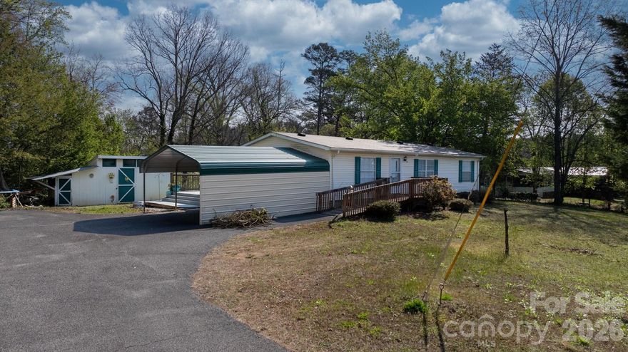 Welcome to this well-maintained 3-bedroom, 2-bath manufactured home offering 1,292 square feet of comfortable living space, nestled on a gently sloping 0.79-acre lot in the desirable Connelly Springs area of Burke County. The property features a double carport along with plenty of additional parking, making it ideal for multiple vehicles, guests, or even recreational equipment. A few scattered trees provide a sense of privacy while still allowing for an open, usable yard. Enjoy outdoor living on the spacious rear deck, and take advantage of the stick-built storage building with an attached chicken coop—perfect for extra storage or hobby use. There is also an above-ground pool already in place, offering potential for summertime enjoyment with a little TLC. Inside, you’ll find an inviting open floor plan connecting the living room and kitchen. The living room features durable laminate flooring, while ceramic tile runs from the hallway into the kitchen and continues into the primary bathroom. The kitchen offers ample cabinet space and functionality for everyday living. The home includes a primary suite with a full bath, along with two additional bedrooms and a second full bathroom. A conveniently located hallway laundry area includes a washer/dryer combo that conveys with the home. Located just minutes from I-40, this property provides easy access to Granite Falls, Hickory, and Morganton—offering the perfect blend of quiet living and convenience.