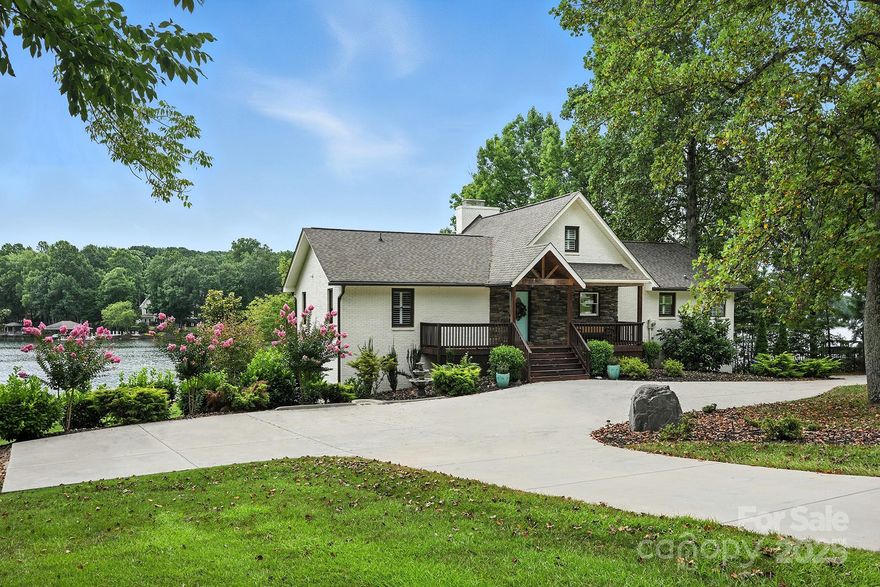 Discover the charm of lakefront living in this furnished cottage-style home. Nestled on Lake Norman with a private dock, 10,000-pound boat lift, and boat house (a rarity!) with electricity and sun deck above it. This inviting retreat is full of character. The vaulted great room features exposed beams, a cozy wood-burning fireplace with floor-to-ceiling stone, and a spiral staircase to a loft. The kitchen is both beautiful and functional, with granite countertops, island dining, and high-end stainless appliances. Wake up to lake views from the spacious primary suite with a spa-like bath and custom closet. A finished walk-out basement offers a warm gathering space with billiard room, full bath, family room with fireplace, wet bar with full-size fridge, and guest suite with bath. Plantation shutters, two laundry rooms, newer well and septic, irrigation system, no HOA dues, and room for a pool if desired! Move-in ready and perfect for lakeside living or a charming vacation rental.