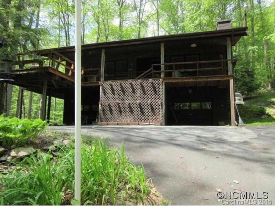 YOU'LL LOVE THE SOUND OF THE CREEK FLOWING THE LENGTH OF THE PROPERTY. Sit out on the covered porch and take it all in. Lovely wooded 5.07 acres giving you privacy. The driveway going up has a parking area at the lower garage/basement level, continue up and you can park and enter the main level. Home was built by the owner who loved wood working. The inside is cozy an comfortable, everything you need on one level. There is a neat finished attic.