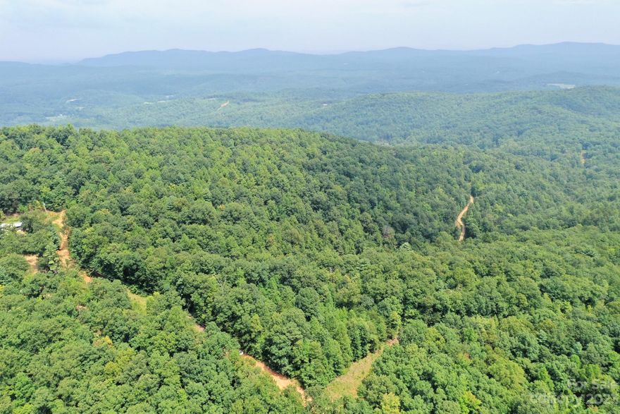 Private 5+ unrestricted acres outside of Morganton. Great homesites with level spaces and potential long range views. Parcel is near the end of a privately maintained driveway with basically one neighbor. No HOA but neighbor states there is a road maintenance agreement and would expect help if property is built upon. Private road edges nearly 1000ft of property.  Property has an older spring water system and septic system but needs verified. Power runs all the way up the private road, so it runs adjacent to property for easy connect (REMC). If visiting property please use 4wd to keep the road in good shape. Please respect the folks that have been enjoying this privacy for many years. Property is 20 minutes off i40 at the Morganton exit.