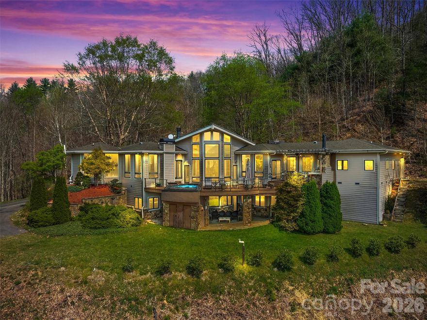 Impressive floor plan with exceptional craftsmanship throughout! This beautifully designed home features 12-foot ceilings, granite countertops, a hammered copper farmhouse sink, hardwood floors with limestone inlay, heated tile floors, and marble in the primary bath. Architectural details such as the dome light ceiling and four fireplaces (two gas and two woodburning) add warmth and character throughout the home. The main level offers a spacious primary suite with ensuite bath, a chef’s kitchen, large laundry room with ample cabinetry, granite countertops, and additional storage, a dedicated office area, and an inviting living room with gas log fireplace. The great room features floor-to-ceiling windows and a wood-burning fireplace, creating the perfect space to relax and take in the surrounding beauty. A gorgeous foyer welcomes you into the home. The lower level is just as striking, offering two guest bedrooms, each with their own ensuite bath, a large family room, wet bar, and direct access to the lower terrace. Paved road to the home, year-round access. Short term rental friendly.