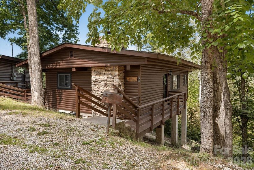 Welcome to your perfect mountain retreat in Nantahala Village! This charming 2-bedroom, 1-bath cabin offers a blend of comfort and convenience, featuring low-maintenance living so you can spend more time enjoying the beauty around you. The cabin comes fully furnished with pine flooring, tongue-and-groove walls and ceilings, and a stone wood-burning fireplace for cozy evenings. The kitchen is equipped with stainless steel appliances, and a large picture window frames serene wooded views from your end-unit location—providing added privacy and tranquility. Enjoy resort-style amenities including tennis courts, a pool, and a fitness center. With easy paved access, you’re just minutes from Bryson City and the scenic Nantahala Gorge. Move right in and start living the mountain lifestyle you’ve always dreamed of!