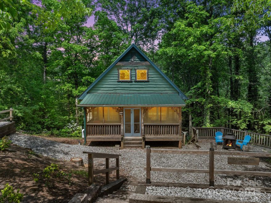 Nestled in the picturesque surroundings of Lake Lanier, this unique INVESTMENT OPPORTUNITY offers a charming blend of rustic elegance and modern convenience. Featuring two parcels that ensure privacy and tranquility. The cabin is adorned with unique, handcrafted elements that enhance its rustic charm and appeal. The cabin comes FULLY FURNISHED, allowing new owners to immediately enjoy or rent out the property. The cozy interior is perfect for relaxing after a day of exploring our beautiful area. The screened porch is great for entertaining or gather around the fire pit for storytelling and marshmallow roasting. The basement recreation room is equipped with sleeping quarters, a kitchenette and full bath. This space is perfect for hosting guests or using as a game and activity area. It has a successful record on the short-term rental market. Proximity to the charming downtowns of Tryon, NC & Landrum, SC offers an abundance of dining, shopping, and cultural options.