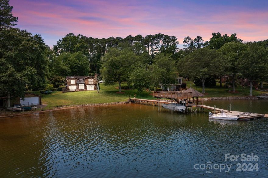 Captivating Lake Norman Views Await You! Nestled on a quiet street, this property offers panoramas of Lake Norman. Boasting a grandfathered boat ramp and boat house, the property sits on a generous .68-acre plot. Main level features a galley style kitchen, cozy bar, dining room, and an office space. Unwind in the inviting great room adorned with a fireplace or relax in the adjacent sunroom housing a hot tub. Ascend the stairs to find the primary bedroom, with an ensuite bathroom, offers a private retreat overlooking the water. Two additional generously sized bedrooms share a hall bathroom, while a loft area provides a perfect spot for a desk, ideal for work or study. Every bedroom boasts enchanting views of the tranquil lake. Step outside to a haven of outdoor living. A covered boat dock beckons, providing an idyllic setting for fishing expeditions or leisurely gatherings with company. Situated in a deep-water cove, the possibilities for waterfront enjoyment are endless.