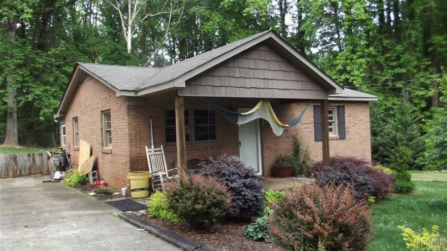 Absolutely adorable all brick doll house in Newton on a nice level lot beside a creek.  Home features 2 nice size bedrooms with oak hardwood floors, full bath, large laundry room and eat in kitchen have tile floors, large living room.  Level back yard with a large single garage/workshop. Paved driveway, nicely landscaped yard, nice neighborhood.  Large front porch.