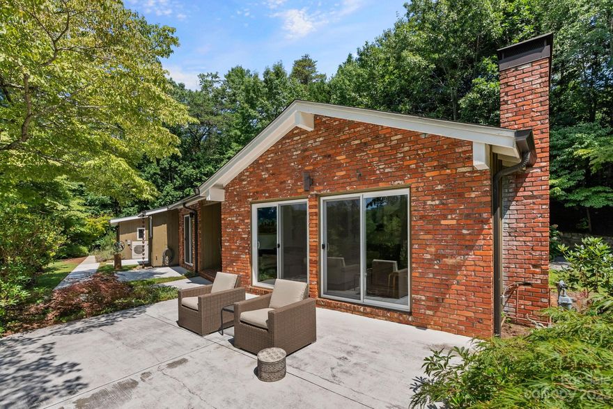 Private, mid-century modern oasis overlooking Beaverdam Valley. Step inside the double entry doors and be wowed by the fabulous architecture and abundant windows, skylights and sliding doors that bring in light, as well as mountain and garden views from every angle. One-level, open floor plan w/ vaulted ceilings, brick fireplace and original hardwood flooring. MCM perfection! Efficiently designed kitchen is open to a breakfast room. Flowing floor plan w/ primary suite, two guest bedrooms and hall bath. Large artist studio — with half bath, office space and storage — could also make a great home office, media or workout space. In every direction, there are outdoor spaces to relax & enjoy serene mountain views, tranquil breezes & wildlife. Backyard features a stone fountain and a pollinator habitat fashioned from flowering native plants and providing a perennial feast for bees, butterflies & hummingbirds. All this and a perfect location, close to north Asheville and downtown amenities.