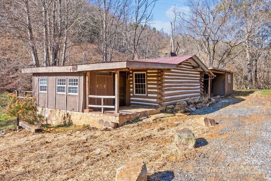 Can not beat this location and price! Charming antique log cabin, ideally situated 5 minutes to Marshall, 25 easy minutes to vibrant Asheville, nestled in a peaceful and a quiet neighborhood. Many repairs and upgrades already completed; a brand new septic system, a new water pump and upgraded new 200 amp electric panel have been installed. Detached laundry/workshop shed plumbing also upgraded. This adorable home offers the perfect blend of coziness and charm. With an inviting open floor plan this home exudes a laid back atmosphere, perfect for relaxing and unwinding. A small, gentle stream flows nearby, adding to the peaceful ambiance. This cabin would make an ideal short term rental opportunity and ready for you to make it your own with endless possibilities.