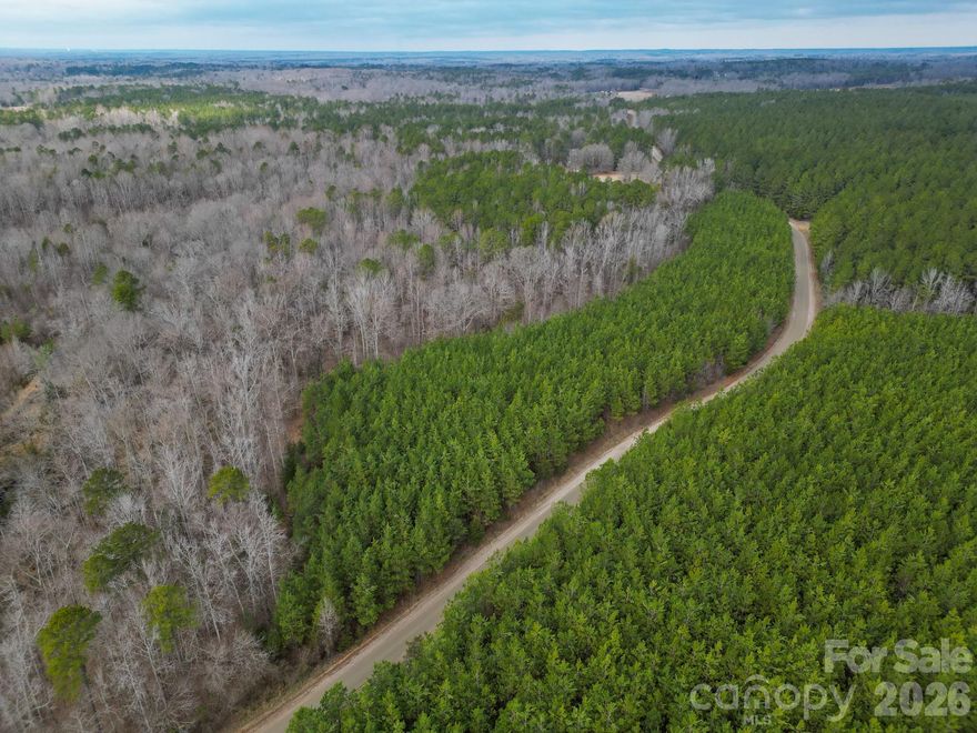 To be surveyed from a larger parent parcel, this beautiful property offers a peaceful rural setting ideal for recreation, homesteading, or your future custom home. Located in Lancaster, SC, this approximately 7.25 (+\-) acres features gently rolling terrain, established planted pines, and mature hardwoods that create a natural backdrop—especially near the creek that forms one boundary of the property. A portion of the tract lies within the floodplain, but potential homesites sit on higher ground.  This property delivers the charm of country living and a little elbow room while still offering convenient access to Lancaster, Waxhaw, and Charlotte.