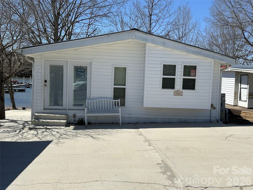 A rare opportunity to own waterfront property in Badin Shores Resort! This park model home is ready for someone to bring their vision and decorating ideas to life. Enjoy wonderful water views from the living area and kitchen, creating a relaxing setting to take in the beauty of the lake. A spacious screened porch stretches across the front of the home, offering the perfect place to unwind while watching boaters launch at the nearby boat ramp or enjoying watching the boats out on the water. The property also features an expansive lakeside yard and a side patio area, perfect for hosting family gatherings, cookouts, and entertaining guests. Inside, the home is ready for updates, presenting a great opportunity to remodel and customize the space. New flooring along with kitchen and bathroom updates would significantly enhance the home's appeal and value. With its prime waterfront location and endless potential, this property is a fantastic chance to create your own lakefront retreat.