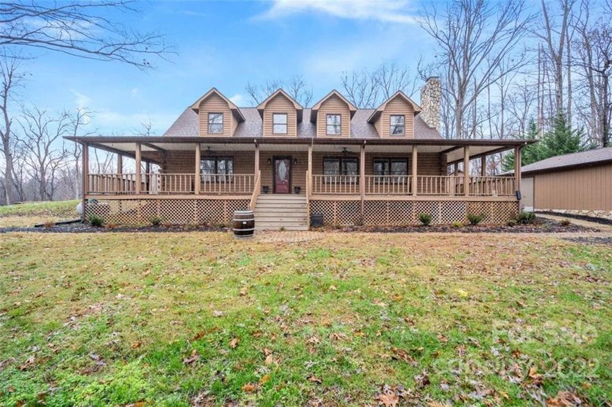 Private 8 acres with quick access to Lake Norman and I-77! This 3 bedroom / 2.5 bath log cabin has a beautiful deep porch and deck offering plenty of outdoor seating.  It sits on a hill beside the detached two car garage. More than enough parking for family and guests.  Natural wood beams and stone fireplace in family room,  primary bedroom on first floor.  Come see all of the potential this amazing property has to offer!