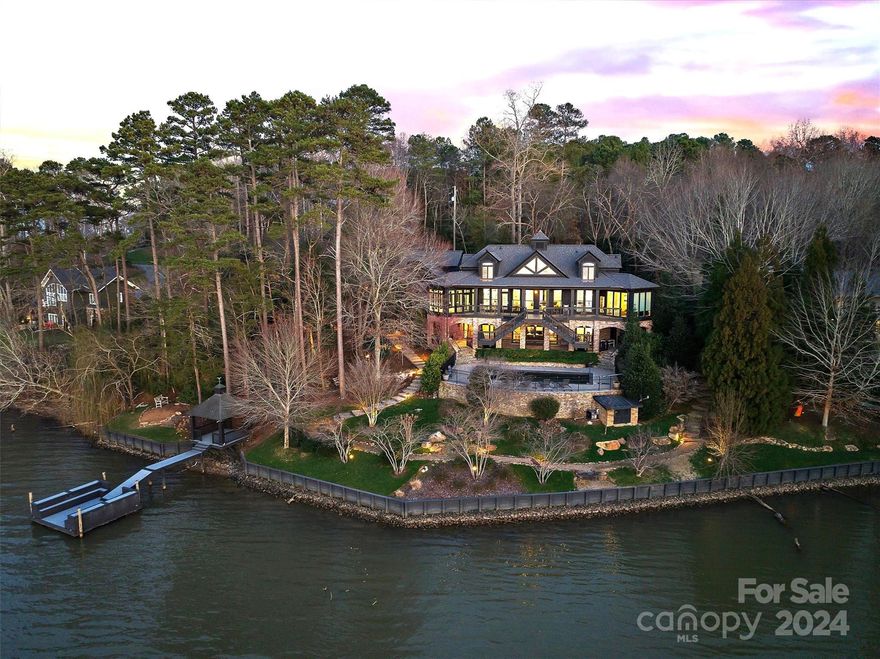 One of Hickory's most sought-after private lake residences, this stunning home was custom built for Mitchell Gold, distinguished furniture brand entrepreneur. Nestled on a quiet lot with over 285' of shoreline on Lake Hickory, this home has been featured in the most prestigious design magazines, including Elle Decor and Architectural Digest. The open floor plan with floor to ceiling windows showcases impressive views of Lake Hickory. The restored vintage doors throughout add a sophisticated mix. Perfect for entertaining, the kitchen features a one-of-a-kind blue Azul Macayuba quartzite island, 48" Viking range, Thermador refrigerator, dual dishwashers, adjoining intimate dining porch. The primary suite is a luxurious retreat, which includes custom millwork, coffered ceiling and a walk-in closet, masterfully designed. The adjoining office enjoys spectacular lake views year-round. Outdoors, a pool and spa are ideally situated to take in the beautiful grounds and spectacular sunsets.