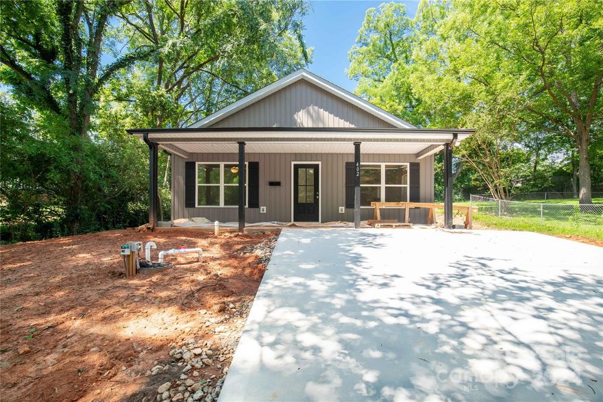 Enter into this stunning new construction and experience the comfort of home. This residence offers three bedrooms and two full baths, boasting a sophisticated slate gray exterior complemented by black trim and shutters. Upon entering, you'll be welcomed by a luminous and open layout featuring alabaster walls and upscale luxury vinyl plank flooring throughout. Pristine white cabinets, granite countertops, and a charming kitchen island enhance the generously sized living room and kitchen areas. The primary bedroom, situated at the rear of the home, exudes a sense of openness and light, complete with its own en-suite bath. Both the primary and secondary baths feature elegant granite countertops. Outside, the rear patio adjacent to the kitchen/dining area provides an ideal setting for entertaining guests or relishing summer evenings.