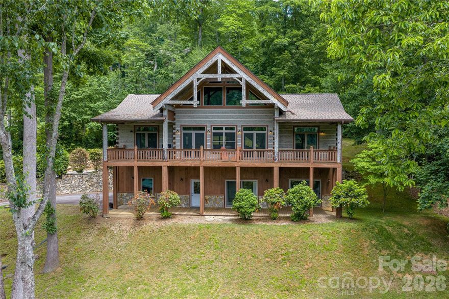 Long-range mountain views set the stage for this exceptional flat log residence. Handcrafted timber frame accents, timeless mountain architecture, and refined finishes create a rare balance of luxury living and rustic elegance. 
Outdoor living is designed for year-round enjoyment with covered porches spanning the full length of both levels. A covered portico provides sheltered arrivals for guests and groceries. Inside, a vaulted wall of glass fills the space with natural light and frames the mountains beyond. The great room showcases light-toned log walls, soaring tongue-and-groove ceilings with exposed beams. and dramatic stonework on the 1st of three fireplaces. The open kitchen showcases expansive stone countertops, island seating, and mountain vistas. The dining area and convenient half bath support easy entertaining. A large laundry/mud room adjoins the kitchen for everyday convenience. Above, the loft overlooks the great room and mountain scenery—ideal for a game room or office. TWO PRIMARY SUITES on the MAIN LEVEL provide exceptional comfort and privacy with a split-bedroom design, mountain views and walk-in closets in both suites. One primary suite features a stone-faced fireplace and tiled walk-in shower, while the second offers a soaking tub. The daylight basement functions as a fully independent GUEST RETREAT or multigenerational space, designed for comfort and privacy. The family room features a fireplace and opens directly to the covered porch. This level includes a full kitchen, full bath, bedroom with a view, and a mountain-view 'flex space' ideal for fitness, studio use, or game room. Offering both interior access and direct entry from the covered porch and driveway, guests can enjoy easy access and private accommodations. Completing this level is an oversized 23x32 two-car GARAGE with dedicated storage and ample room for a workshop. Extensively improved with a focus on comfort, preservation, and long-term performance, this exceptional log home offers the rare benefit of major infrastructure UPGRADES already completed. Recent investments include a complete roof installation, replaced septic system tank and components, and replacement of both HVAC systems with new compressors and air handlers for reliable climate control.
Recognizing the importance of maintaining a premium property, an industrial-grade built-in dehumidification system was added in the guest retreat on the lower level to optimize environmental freshness and support long-term home preservation. Additional enhancements include an oversized water heater for increased capacity and a newly installed inline water pressure system designed to stabilize and improve water delivery throughout the home. Surrounded by well-maintained homes, the location and setting offer mountain scenery in two directions elevated by majestic trees and the gently contoured yard is walkable. Cool 2,780' elevation supports comfortable year-round living.  Located behind the gated entrance of Cobblers Knob, paved driveway and gentle roads connect to state-maintained roads. Easy access to Asheville, Waynesville, and Maggie Valley. The Cataloochee area of the Great Smoky Mountains is nearby. Plus the Blue ridge Parkway, snow skiing and Harrah's Casino are a short drive. Just 19 minutes by excellent roads to Downtown Waynesville and 8 miles/16 minutes to major grocery stores. Many excellent dining options await even the most sophisticated foodie. In Summary: This thoughtfully improved mountain retreat offers the rare combination of luxury craftsmanship, breathtaking views, easy year-round access, and substantial completed infrastructure upgrades. Enjoy a walkable yard, gentle mostly paved access, cool mountain elevation, and a private gated setting. Conveniently located near hiking, dining, shopping, golf, skiing, and outdoor recreation, this exceptional property delivers the mountain lifestyle buyers seek—with the comfort, quality, and peace of mind they rarely find.