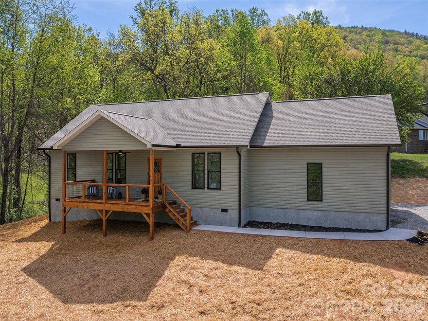 Experience the ease of brand-new living in this beautifully situated home, perched on a rolling one-acre lot designed to maximize its long-distance mountain views. The covered front porch offers a peaceful vantage point to enjoy the scenery, while the back deck provides a functional space for weekend grilling and outdoor gatherings. Inside, the home features a popular split-bedroom floorplan that provides a comfortable flow and added privacy for the primary suite. The interior is anchored by durable LVP flooring that runs throughout the entire home, offering a cohesive and low-maintenance aesthetic. A bright, modern kitchen serves as the centerpiece of the open living area, featuring an impressive amount of cabinetry, a versatile center island, and attractive granite countertops. These quality finishes carry into the bathrooms, which are well-appointed with granite vanities and a tasteful tile shower in the primary bath. Practicality meets comfort with an attached two-car garage and a yard that offers plenty of rolling space for play. Located just a short six-minute drive from local grocery stores and dining, this property offers the ideal balance of a quiet, scenic retreat with effortless access to daily essentials. This is an excellent opportunity for anyone seeking a fresh new home in a picturesque setting.