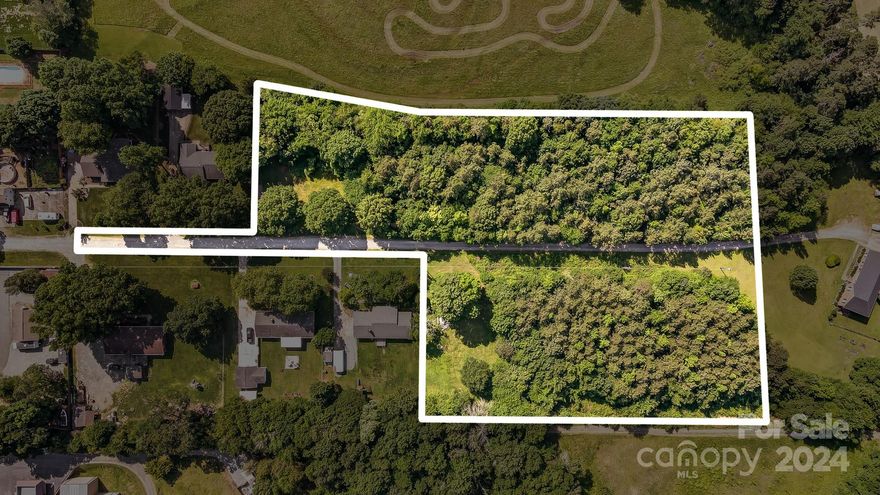 This is a fantastic lot for a single-family home, duplex, or tiplex. This 4-acre property is private and ready to go—great location and convenient to 485 and 77. A private road is in place and has a road agreement with the neighbors. The property backs up to a golf course and a farm.