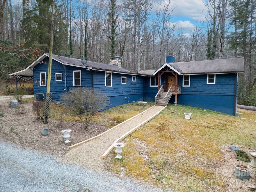 Escape to this beautifully refurbished and fully furnished mountain retreat set on approximately 4 private, unrestricted acres. With nearly 605 feet of road frontage, a road easement along the eastern border, and gently sloping terrain, the property offers exceptional flexibility for future possibilities. Relax and take in the surrounding peaceful forest from your oversized private back deck - recently upgraded with new decking and railings. The home has been freshly painted inside and out, and updates include a new bathroom cabinet and a spacious walk-in pantry with new LVT flooring, among other thoughtful improvements. Originally built as a 1950s mountain getaway, the home retains its authentic character with handcrafted doors, exposed ceiling beams, and wood-paneled walls, creating the timeless charm of a classic mountain lodge. A 2009 addition significantly expanded the home, adding an expansive primary suite with fireplace, a library, and a large bathroom. The lower level features flex space with a secondary kitchen and half bath, ideal for guests, hobbies, or extended stays. One of the home’s most distinctive features is the secret circular staircase hidden through the primary closet back door, leading to the basement. There you’ll find lockable storage rooms concealed behind a bookcase, revealing a steel security door and two secure rooms with shelving and gun racks—perfect for storing valuables. Additional highlights include a Generac gas generator for peace of mind during severe weather. Conveniently located with an easy drive to Brevard, DuPont State Forest, Caesars Head State Park, and the restaurants and shops of Cedar Mountain, this unique mountain property blends privacy, character, and modern comfort in an ideal location. Situated on Cedar Lane, a level gravel road maintained by the state, providing easy year-round access.