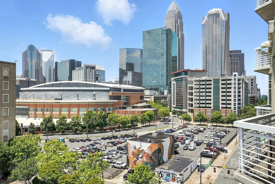 9th floor condo with wonderful skyline views, located in the heart of Uptown Charlotte. This unit is the top floor on this side of the building. Industrial style, open concept home perfect for city entertaining. Kitchen boasts smooth granite counters and large island. Laminate wood flooring throughout, plus large windows. Spacious bedrooms with large closet with custom shelf system and bathrooms. Large balcony overlooks the Arena. Walk to work, dining, entertainment, and Light Rail station. Building offers a rooftop terrace with city views for socializing and relaxing. Enjoy all the Uptown life has to offer! Refrigerator, washer/dryer included. Fresh paint throughout.  Two parking spaces in secured deck.