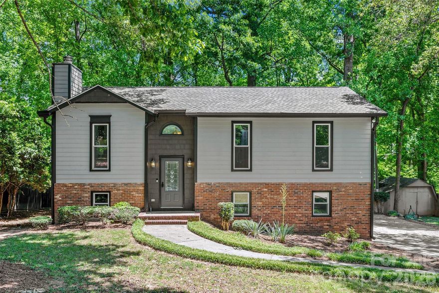 There is so much to love about this beautiful home in Fort Mill with NO HOAl!! With a unique split level design and vaulted ceilings, this home features an open, bright floorplan and a brand new kitchen with all new cabinets, quartz counters and appliances! The roof, gutters, windows and doors have also all been replaced in the past year, and the flooring and bathrooms are also recently renovated. The main level features new recessed lighting, beautiful LVP flooring, a stunning stone wood-burning fireplace, fresh neutral paint, a primary suite with a beautiful tile shower, two additional bedrooms and a hall bath. The lower level features a large bonus room with a kitchenette, a fourth bedroom, and a full bathroom with a laundry area. The 0.40 acre lot has privacy fencing and backs to woods for tons of privacy. The quiet community is just minutes from everything in Fort Mill, including the Anne Springs Close Greenway, shopping and restaurants, and is an easy commute to Charlotte. Zoned for highly rated Fort Mill Schools and low SC taxes! Don't let this beautiful home get away!