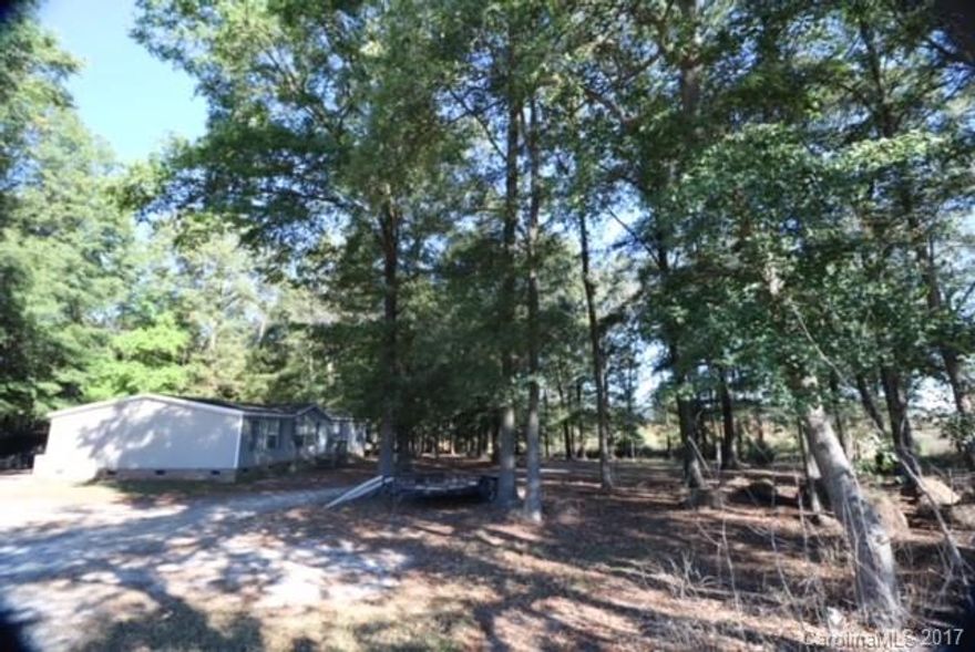 Enjoy the privacy on this 2 acre hideaway. Manufactured Double Wide Home, 3 Bedroom, 2 Bath Home home with dine in kitchen, formal living room, family room and laundry. Cathedral Ceilings through out the home provide an open feel as you walk the home. This property is flat and wooded providing you with the perfect private get away while only being minutes away from Monroe and a quick trip into Charlotte and surrounding areas.