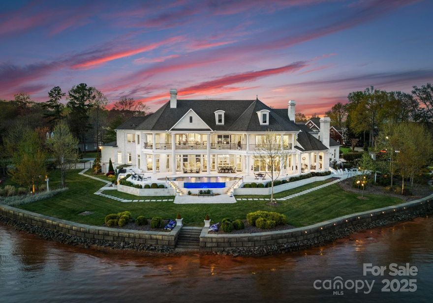 Indulge in lakefront luxury at Point Place, an award-winning masterpiece by PTI Design, Pippin Home Designs and Spivey Construction. Set on 611 feet of pristine waterfront, this estate offers breathtaking 220-degree lake views, capturing sunrise and sunset. Enterra infinity pool and spa create an outdoor oasis, while a limestone walkway leads to the grand entrance of this brick/limestone estate. A circular driveway with white granite and cobblestone paver accents offers guest and owner parking with a 3-car garage. Designed for comfort and elegance, this home features solid white oak Carlisle floors, extensive molding/wainscoting, custom Volute staircase, & soaring ceilings. The 2-story Great Room boasts massive windows for endless lake views, Fine Art chandeliers, and motorized smart shades. All bedrooms have ensuite baths, two opening to a covered balcony with pool & lake views. Main-level primary suite, game room, elevator, private beach & custom dock complete this lakeside retreat.