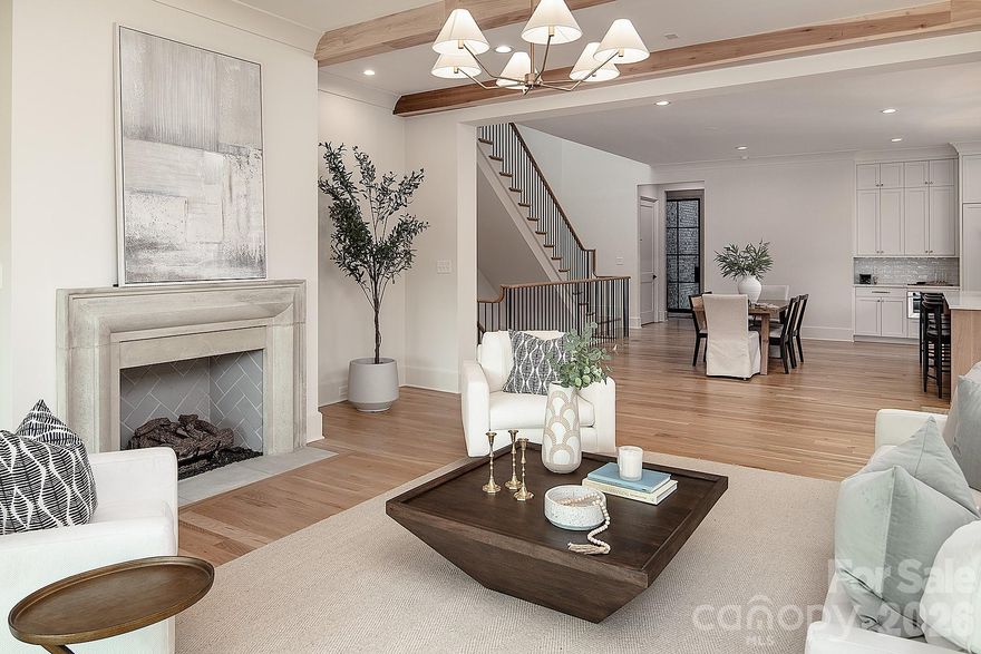 Nestled on nearly half an acre in the heart of prestigious Myers Park, this luxury new construction home delivers the ultimate in modern elegance and craftsmanship. With the Greenway and sidewalk access directly behind, the setting perfectly balances privacy and connectivity. The open-concept gourmet kitchen is a showpiece that keeps entertaining at the forefront.  The living room, anchored by a cast-stone gas fireplace, flows seamlessly to the covered back porch with a second fireplace - ideal for indoor-outdoor living. Upstairs, three spacious bedrooms each offer en-suite baths and walk-in closets, including a serene primary suite with spa-level finishes. The lower level expands the home’s versatility with a sprawling bonus/rec room opening to a covered terrace, plus a private bedroom suite and abundant storage. Designed with future flexibility in mind, the residence is already plumbed for a secondary kitchen, structurally supported for an elevator, and includes space for a wine cellar. Timeless design, refined detail, and an unmatched location define this Myers Park masterpiece.