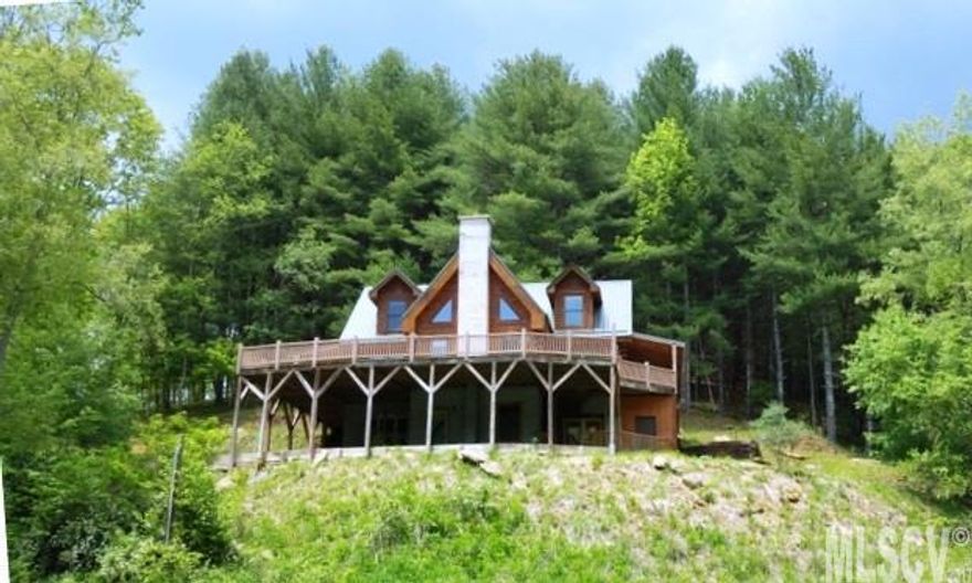 A big log home ON the river with NO OTHER HOME in sight. Private location at end of road. HUGE decks with views of field and river and rocky ridge beyond. Your own trout fishing paradise on highly prized Helton Creek, a stocked trout stream which also has native trout. The river makes a dramatic turn against a cliff ridge in front of this house and runs from one end of your panoramic view to the other. Fantastic setting AND a spacious log home at a great price - a rare combination. 3BR/3.5BA log home has guest apt suite in lower level with lovely kitchen #2. Beautiful main level kitchen and dining area have river views. Great room with vaulted ceiling, fireplace--light, bright room. Large loft and bedroom/bath on upper level. Plenty of decks and porches. Basement level has 4 finished rooms - large eat in kitchen, bedroom and bath and a bonus room. Also in basement: utility room, second bonus room with flue for wood stove. Outside storage room. Very rough, 1/2 mile access road.