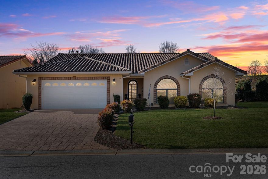 Welcome to 19 Pacifico Drive, an elegant single-level home offering refined comfort and exceptional indoor-outdoor living. The timeless stucco exterior, tile roof, and stamped concrete driveway create striking curb appeal. Inside, vaulted ceilings, arched windows, and abundant natural light highlight the open living areas with a cozy fireplace. The kitchen features granite countertops, stainless steel appliances, and generous cabinetry, flowing easily into the main living and dining spaces. A bright sunroom opens directly to the outdoor living area. The primary suite offers a spa-inspired bath with dual vanities, a soaking tub with jets, and a walk-in shower. The fenced in backyard truly sets this home apart, featuring a beautifully designed paver patio, level lawn, and versatile spaces ideal for entertaining or quiet relaxation, creating a rare sense of privacy and retreat. Meticulously maintained in a desirable Asheville location. Whole home generator provides peace of mind.