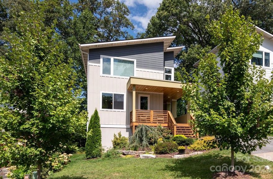 Modern GreenBuilt, Energy Star home by JAG Construction in Craggy Park — West Asheville’s unparalleled community designed to connect people and sustainability.  Come home to streamside trails, organic gardens, and a private park, just a short walk to town. This gorgeous customized home shines with a fantastic open light-filled floor plan designed by award-winning Wilson Architects. Tasteful features include a gourmet kitchen, dedicated main-level office, beautiful hardwood floors, and oversized windows for abundant natural light. Three bedrooms and two full baths on the second level include the primary suite featuring a vaulted ceiling, two closets, and ensuite bathroom. The premium finished walk-out basement boasts polished concrete floors, a large bedroom, full bathroom, and an amazing media/bonus room. Desirable outdoor living with a covered wraparound front porch, sunny back deck, and covered lower-level patio. More tool + toy storage underneath the back deck and front porch.