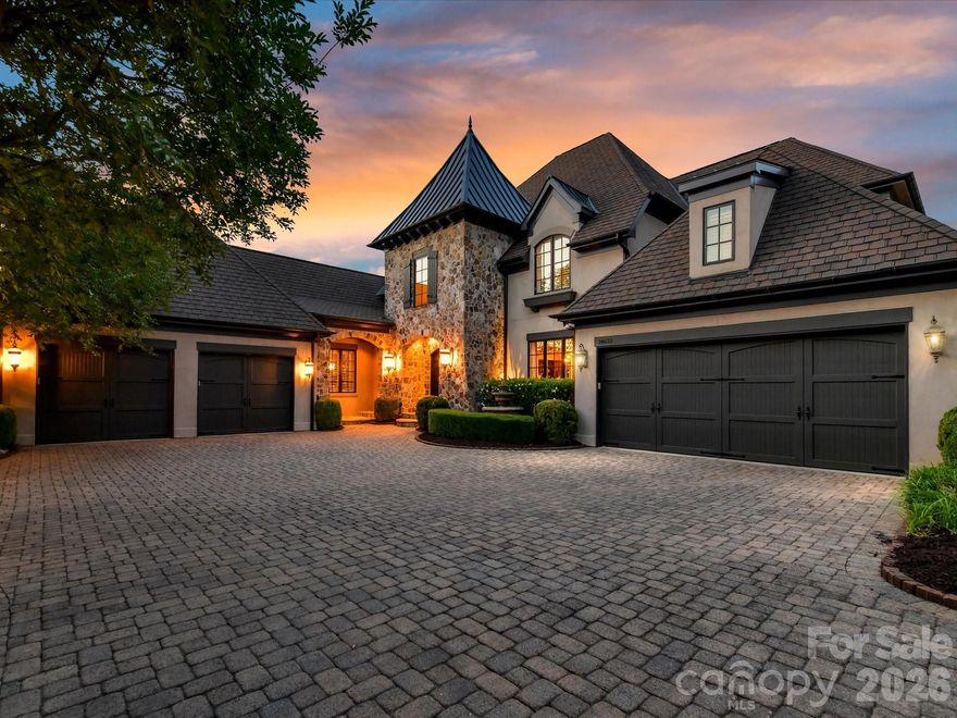 Set along the 11th fairway in Ballantyne Country Club, this extraordinary estate is a masterclass in timeless luxury, architectural elegance, and resort-style living. Tucked behind a dramatic tree-lined paver drive, and manicured lawn, the residence immediately captivates with its commanding presence and breathtaking golf course views from all three levels.
Designed for both grand-scale entertaining and refined everyday living, this remarkable home offers six bedrooms, seven full baths, and two half baths with meticulously curated details throughout. A soaring two-story foyer welcomes you inside, where a sweeping curved staircase sets the tone for the sophistication that unfolds beyond. Just off the entry, a richly appointed office with vaulted wood accented ceiling and fireplace creates an inspiring retreat, while the elegant dining room with coffered ceiling flows to a butler’s pantry complete with a Sub-Zero wine refrigerator.
At the heart of the home, the gourmet kitchen is both stunning and functional, featuring an oversized island with microwave and warming drawer. A 6 burner Wolf gas range with custom hood, d/w, walk-in pantry and SubZero refrigerator, complete the kitchen.  The adjoining breakfast area and keeping room are bathed in natural light, highlighted by a striking tongue-and-groove wood ceiling and panoramic fairway views from every window. The grand great room showcases a coffered ceiling, custom built-ins, and a gas fireplace, with direct access to the expansive upper terrace overlooking the resort-inspired grounds.
The terrace spans across the back of the main level, offering a seamless indoor-outdoor lifestyle with tranquil golf course views.  The perfect place to relax. Below, the spectacular outdoor living experience continues with a saltwater pool and spa, cascading water feature, dual fire bowls, outdoor fireplace, flagstone patio, and outdoor kitchen. A dedicated pool bath with shower enhances the convenience of outdoor living..
The main-level primary suite is a private sanctuary designed with exceptional detail, featuring a vaulted wood-accented ceiling with cove lighting and fireplace. Luxurious spa bath with heated floors, separate vanities, Jacuzzi tub, oversized shower with pebble stone flooring, and dual custom closets. Additional main-level highlights include an oversized laundry room with extensive cabinetry and sink, two powder rooms, a drop zone with built-in desk area, elevator access to all three levels, and entry to one of two 2 car garages. Second 2 car garage access is near the front door/office with covered side entry 
Upstairs, three spacious guest suites each offer ensuite baths, including one with a Juliet balcony overlooking the golf course and another designed to function beautifully as an additional primary suite. A large bonus room with closet and an additional laundry room complete the upper level.
The walkout lower level was thoughtfully designed for unforgettable entertaining and multi-generational living. A dramatic curved staircase leads to a wine room with iron doors, full-size Sub-Zero wine refrigerator, wine storage and an accent window opening to the kitchen/entertaining area. The expansive family room features a stone fireplace, custom built-ins, and a full secondary kitchen, creating endless possibilities for hosting. This level also includes a billiards and game area, flex/bonus room, two additional bedrooms (one currently being used as a gym), two full baths, and a laundry hookup. 
This is more than a home, it is one of the most prestigious offerings in Ballantyne Country Club, where exceptional craftsmanship, timeless architecture, breathtaking scenery, and resort inspired living come together in one unforgettable estate. Welcome Home!
Club amenities require membership