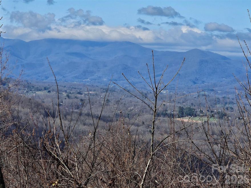 Perched at an impressive 3,400 feet in the prestigious Summit of Asheville, Lot #50 presents a truly rare opportunity to create a private mountain estate unlike any other. This exceptional homesite offers a highly favorable build area suitable for up to three residences—one primary home and two additional dwellings—an uncommon and valuable feature ideal for a legacy property, guest homes, or a multi-generational retreat. Wake each morning to mesmerizing sunrises and unwind in the evening with vibrant, layered sunsets stretching across the horizon. The lot boasts permanent, unobstructed long-range views overlooking the breathtaking Pisgah National Forest, ensuring your viewscape remains.