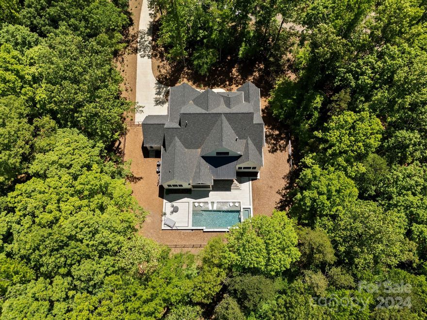 Welcome to your private retreat in the well-sought area of Davidson, NC. This property is privately situated on 3.5 acres in Maple Grove, a cluster of 6 estate sized lots and luxury homes. This pristine property has been thoughtfully designed with no expense spared. Features include uniquely designed ceilings, herringbone flooring patterns, exquisite lighting, oversized scullery, imported handmade Italian tile throughout. Kitchen features natural Vancouver Quartzite, 2 separate convection ovens with 6 burner range, hearth oven, spacious kitchen island. Primary suite on main with luxury bath and 2 walk-in closets. Second suite and office on main. Your statement staircase leads you upstairs to your library, media room and additional bedrooms. Veranda with retractable screen and outdoor kitchen overlook your luxury pool and serene setting. This lot site is unique as it touches Fisher Farm Park and has direct access to hiking/biking trails and Davidson Greenway. Truly a unique opportunity.