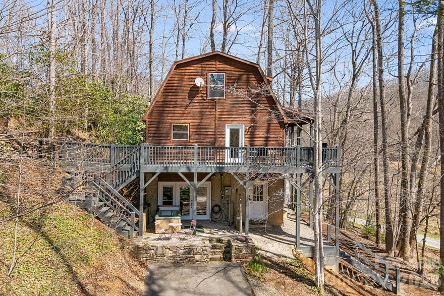 Nestled on a serene 0.74 acre wooded lot in Black Mountain, this charming Gambrel-style cabin blends privacy, comfort, and convenience. A short drive away from downtown’s galleries, boutique shops, and restaurants, it offers a true mountain retreat with easy access to town amenities.
Built in 1999, the home features 2 bedrooms and 2 bathrooms across approximately 1,420 square feet of thoughtfully designed living space. Inside, natural wood tones, bamboo floors, hickory cabinetry, and granite countertops bring a fresh, modern touch to its classic cabin charm. Abundant windows fill the home with natural light and frame peaceful forest views, seamlessly connecting indoors and out.
Step outside to your private sanctuary, where a nearby creek provides a soothing backdrop for afternoons on the deck or evenings in the hot tub under the stars. 
Ideally situated for nature lovers and wellness enthusiasts, the property is close to scenic trails and meditation spaces at The Light Center, while offering easy access to Black Mountain’s vibrant community and Asheville’s cultural and culinary attractions.
With proven success as a short-term rental and a flexible layout suited for a full-time residence, weekend escape, or investment opportunity, 41 Gold Anchor Lane offers an authentic mountain lifestyle in one of Western North Carolina’s most desirable areas.